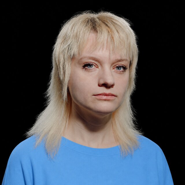 AI-generated portrait of Amanda Askell wearing a DoomBench-blue top against a black background.