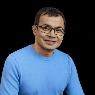 AI-generated portrait of Demis Hassabis wearing a DoomBench-blue top against a black background.